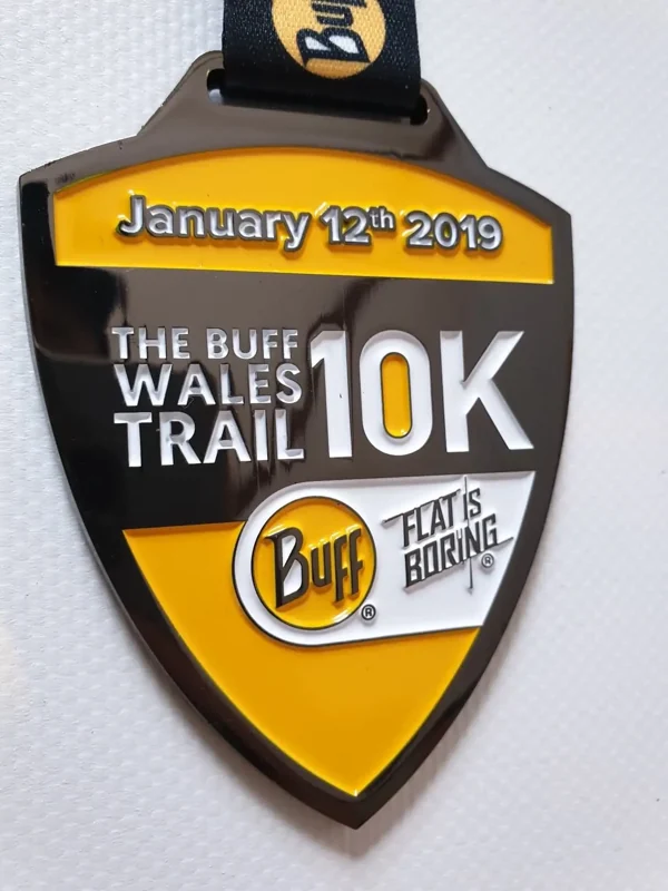 Shield-shaped Wales Trail 10K medal with yellow and black enamel design